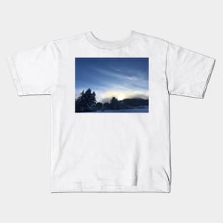 Sunset over a snow covered mountain Kids T-Shirt